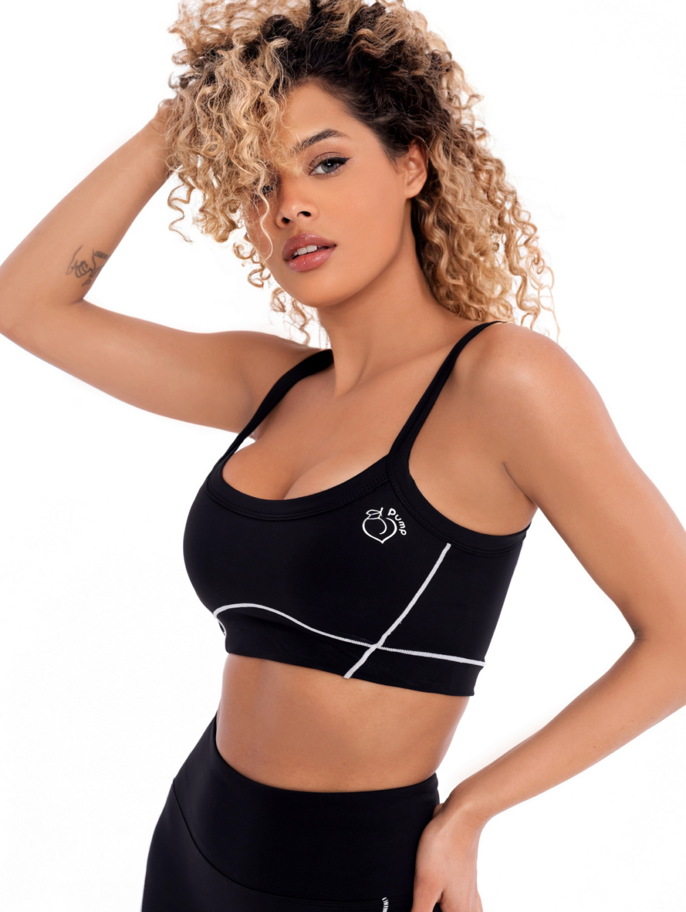 Black sports bra with white lines, black straps and padding by Peach Pump