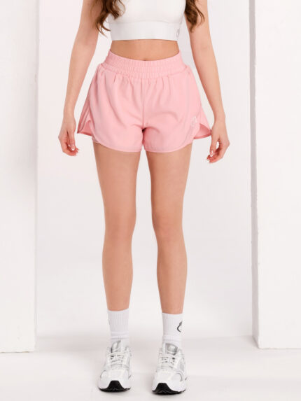 Pantaloni scurți sport roz cu colanți pe dedesubt și buzunare laterale.