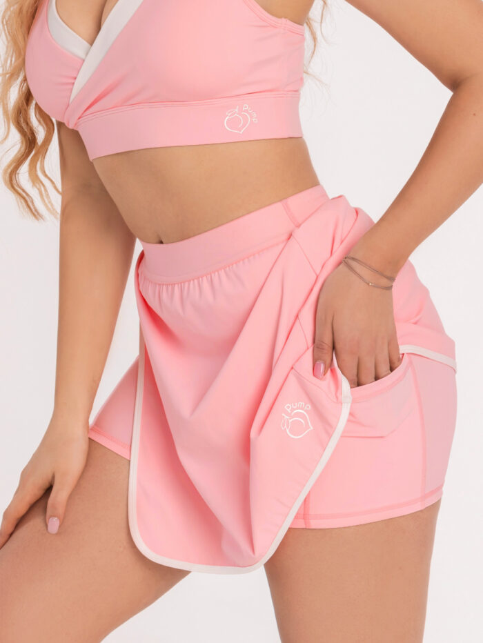 Różowa spódniczka sportowa z bocznymi kieszeniami i dużym rozcięciem z białą lamówką