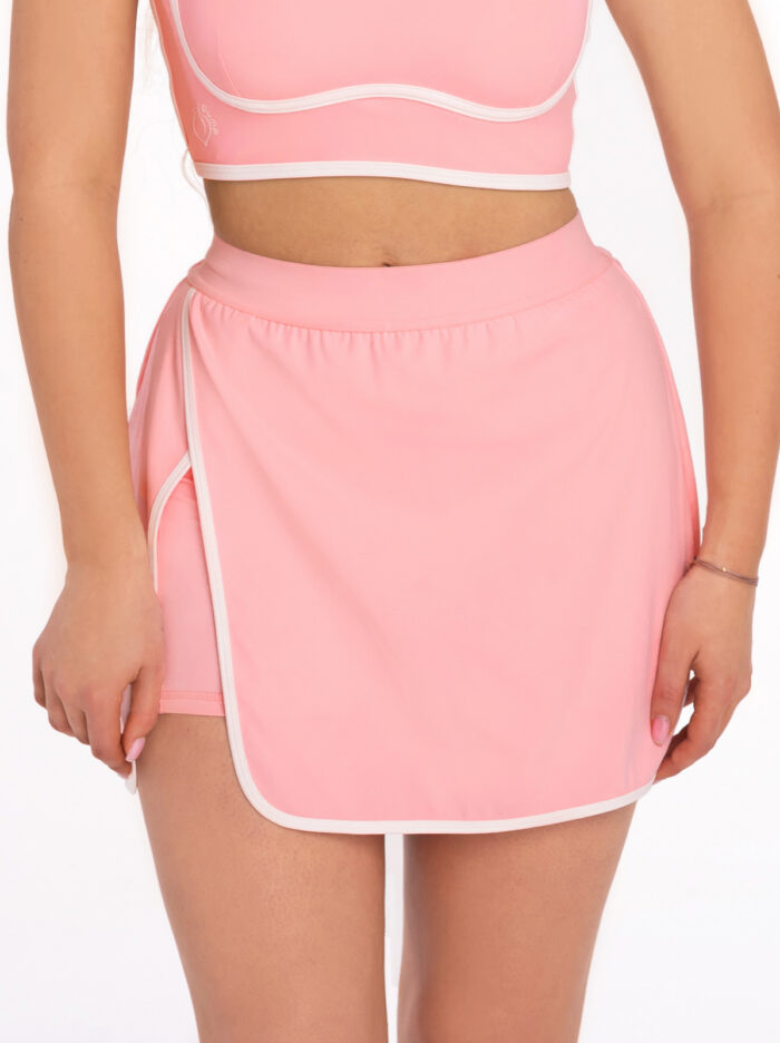 Różowa spódnica sportowa z rozcięciem i legginsy z kieszeniami na dole