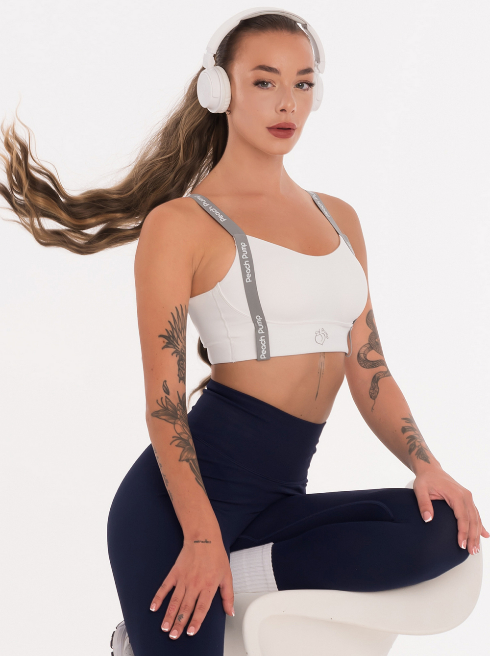 Bílá fitness podprsenka s vycpávkami a nápisem Peach Pump