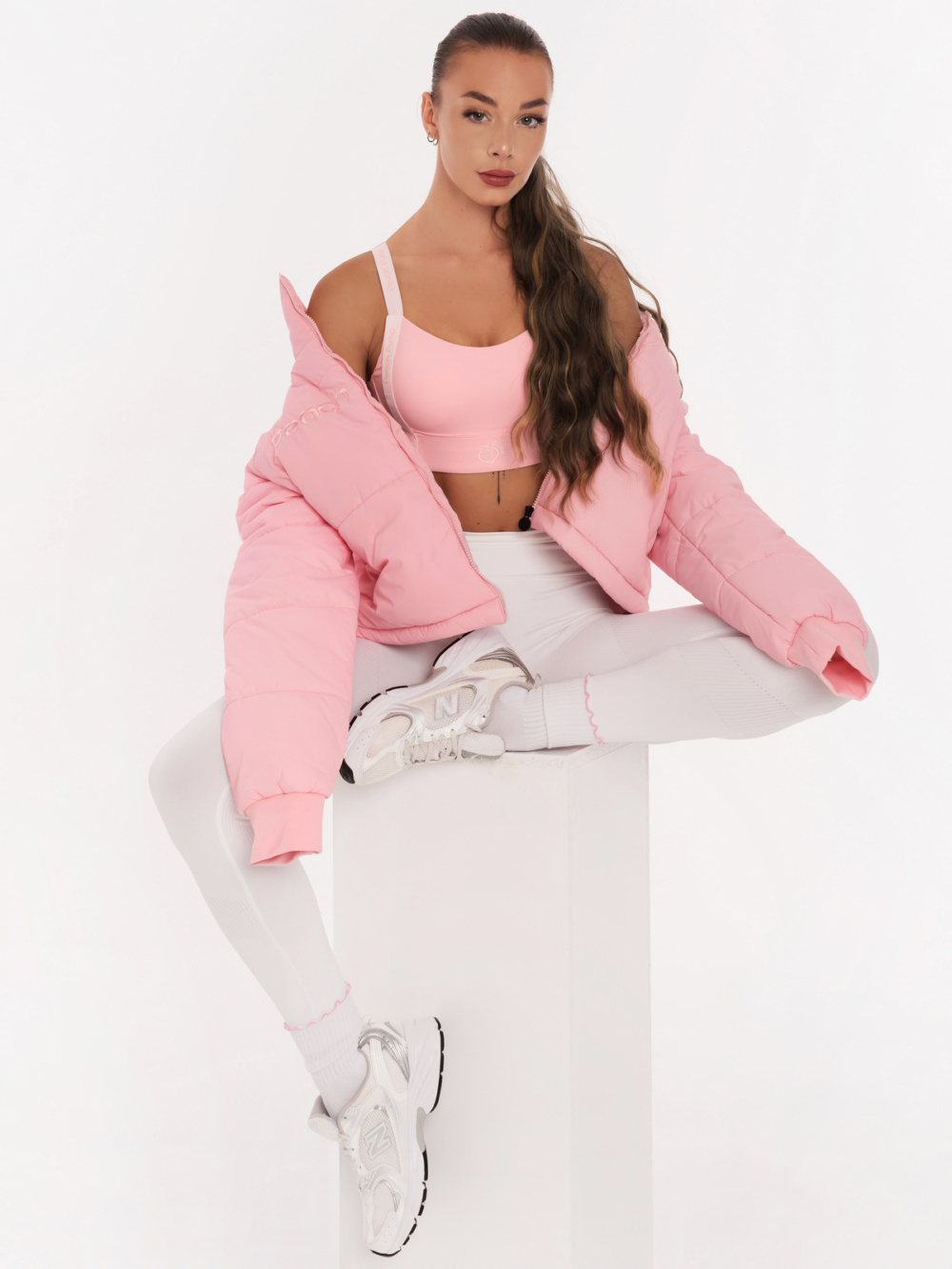 Women's pink sports bra with padding and Peach Pump lettering along the length