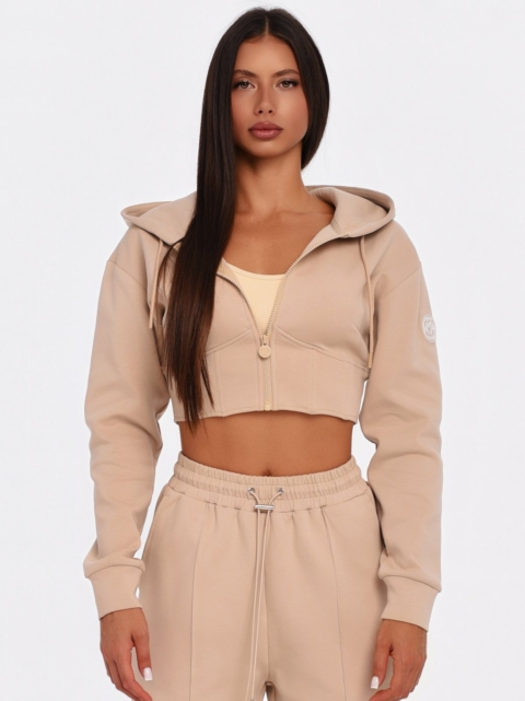 Beiger Cropped Hoodie mit großer Kapuze und korsettinspirierten Nähten.